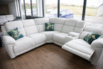 Cream electric recliner corner sofa with chaise seating and padded armrests