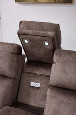 Grey recliner chair back with round button insets and a small control switch panel