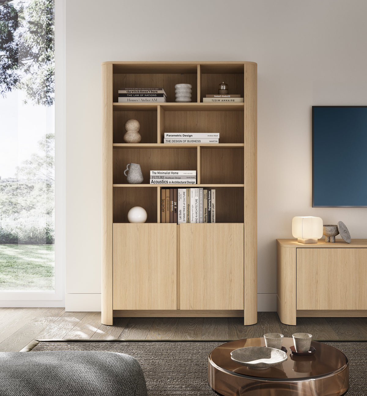 Light oak bookcase with cubby shelving and two bottom cabinet doors.