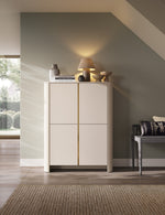 White highboard with gold vertical stripe and doors, styled with countertop decor on top