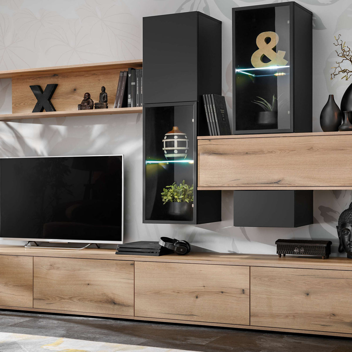Living room wall unit with light wood cabinetry, black panels, and open shelves for TV