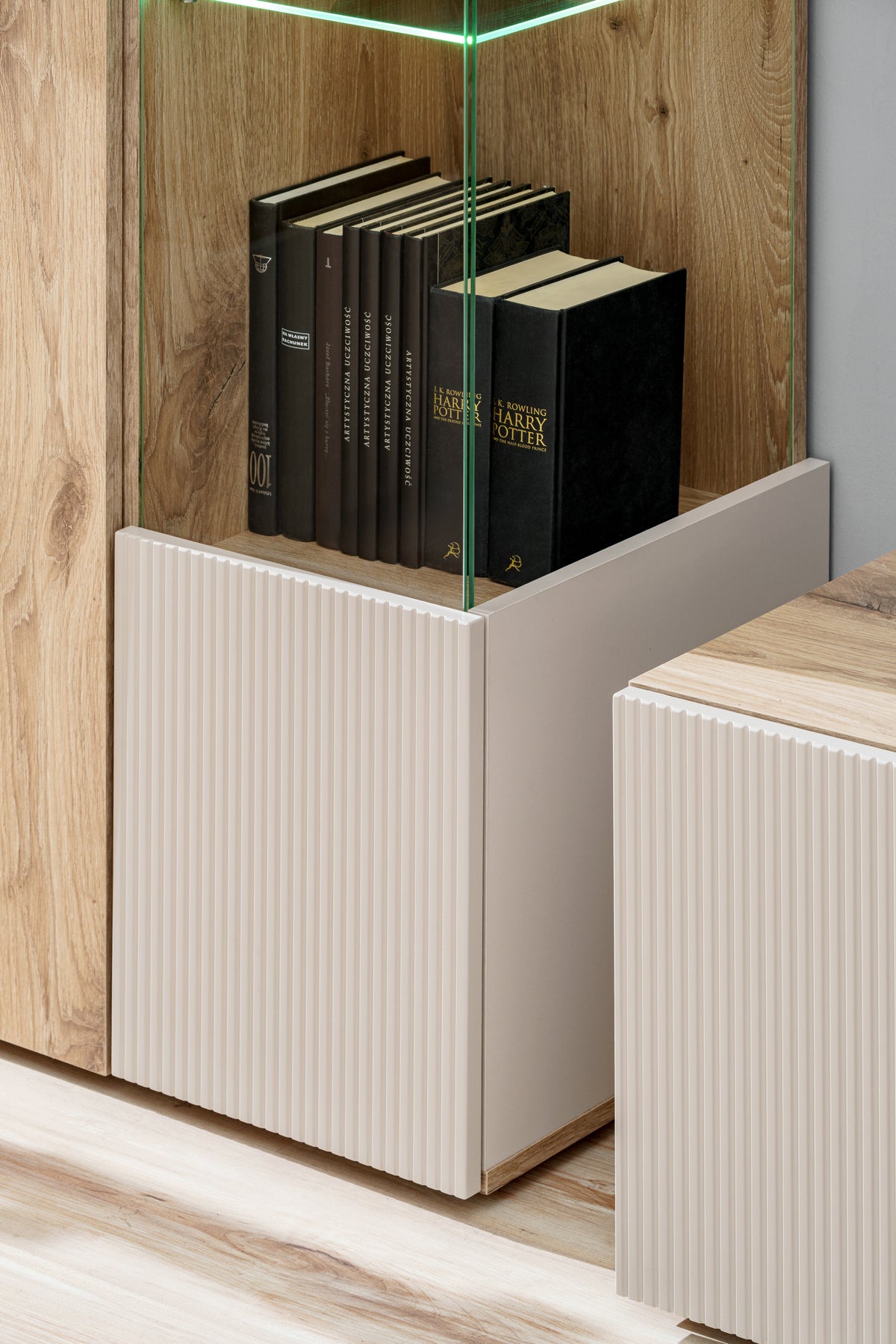 Cabinet base with ribbed fronts and open storage for books
