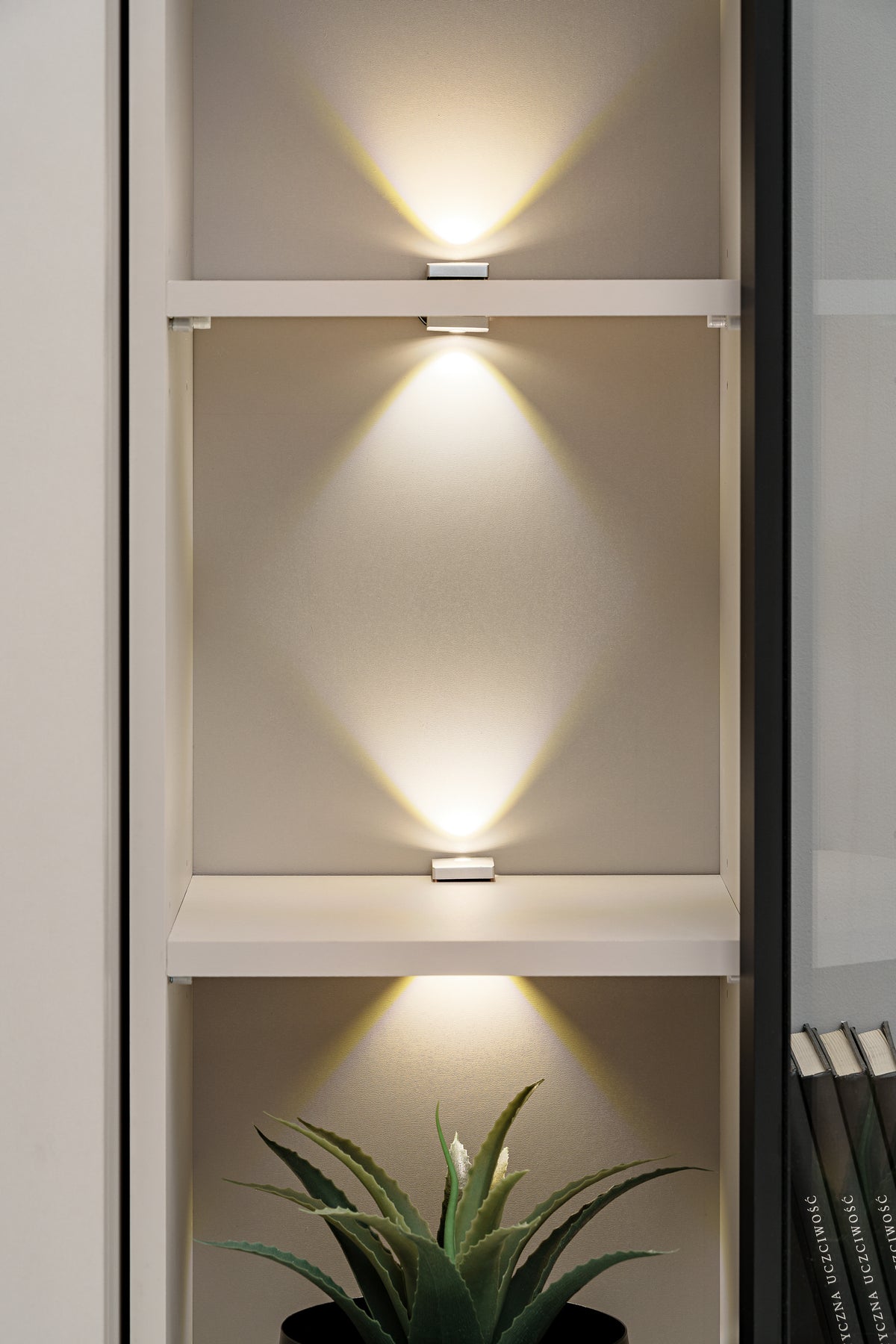 Open media wall cabinet with lit shelves and glass-front compartment