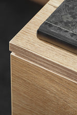 Close-up of light oak-style wood panel edge with black accent top molding