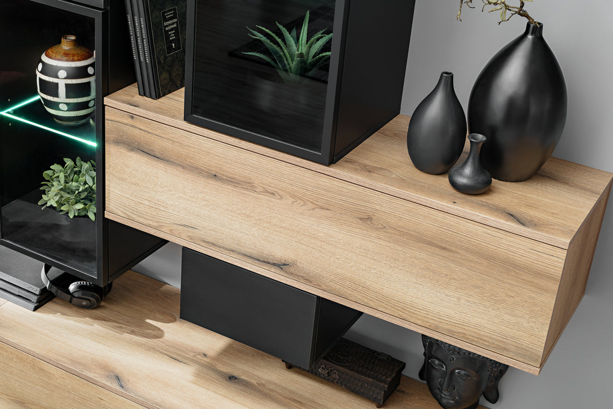 Wall unit console with light wood face, black compartments, and lower storage doors