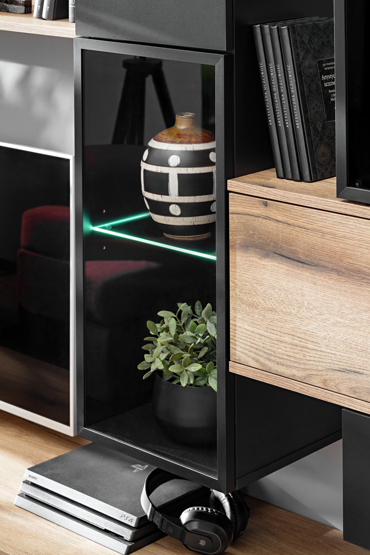 Wall unit with open black shelves, light wood drawer fronts, book storage and decor space