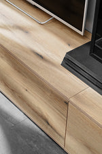 Oak media wall TV console with black base and wood-grain doors/handles