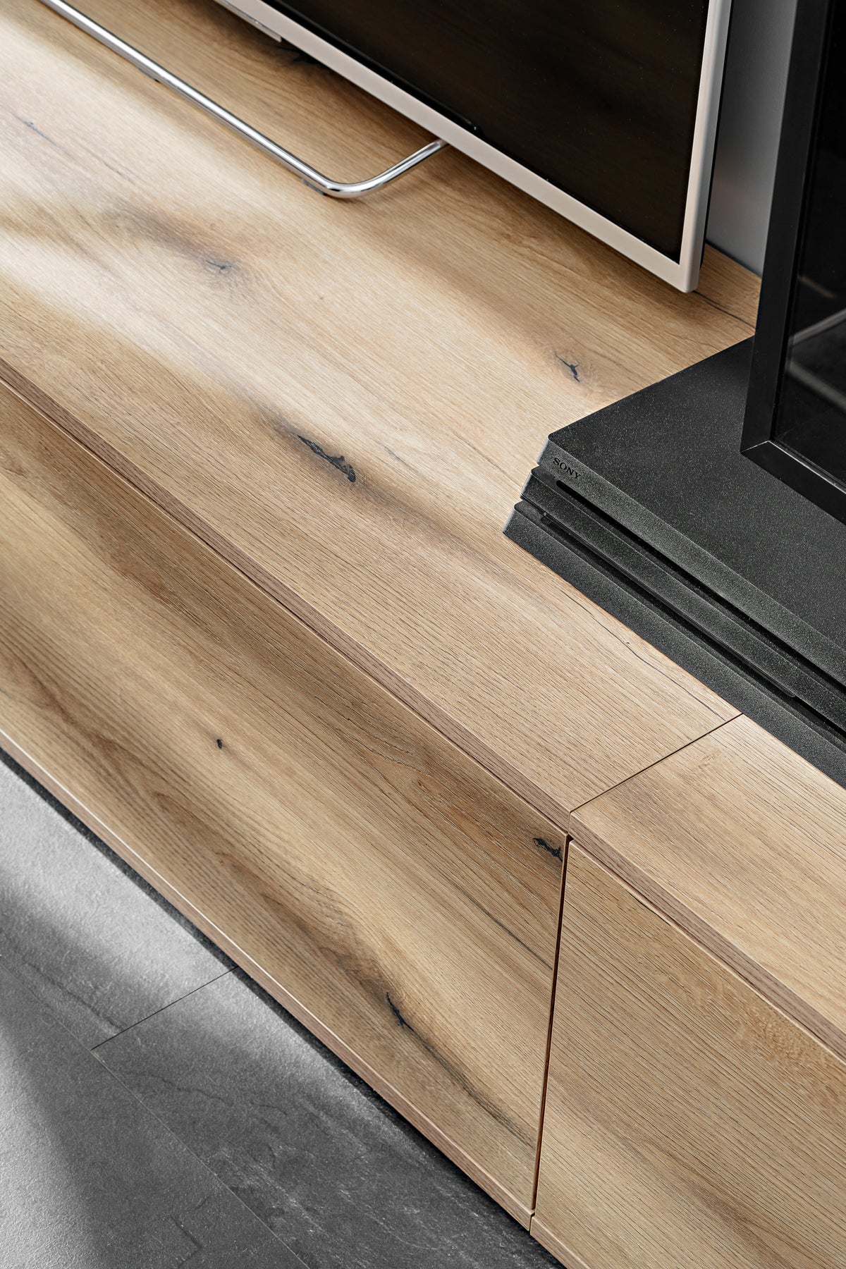 Oak media wall TV console with black base and wood-grain doors/handles
