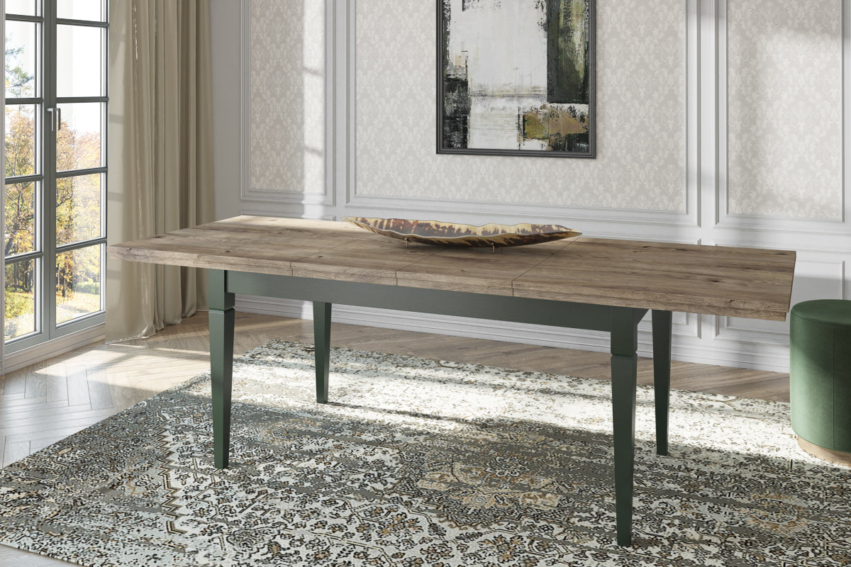 Extendable dining table with rustic wood top and dark green legs, three-quarter view.
