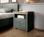Dark gray bedside table with open cabinet and two drawers, brass knobs