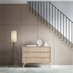 Three-drawer light wood chest with gold triangular handles and slim tapered legs