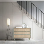 Light wood three-drawer chest with gold triangular handles and slim tapered legs