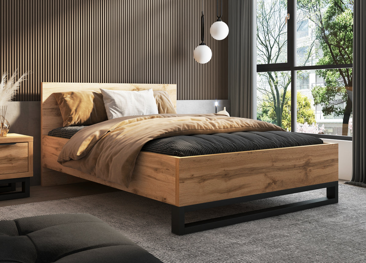 Wood bedside table with drawer and black base beside bed frame