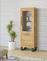 Tall slim wood display cabinet with glass door panels and dark metal feet