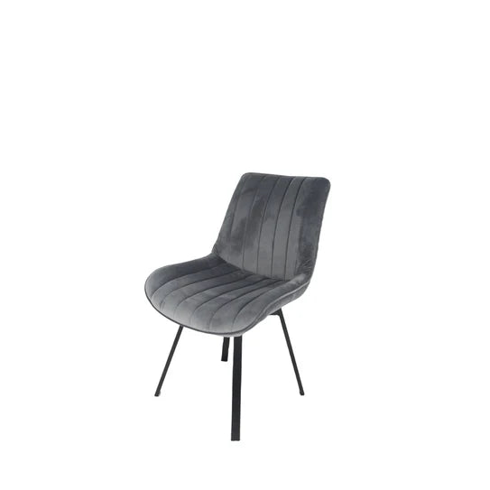 Grey velvet upholstered dining chair with curved back and black splayed legs