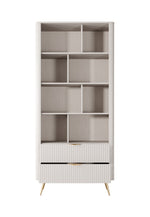 Light beige bookcase with open shelves and ribbed lower cabinet with gold pull