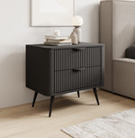 Black bedside table with two drawers and ribbed fronts beside a sofa
