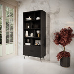 Black bookcase with open shelves and ribbed doors, styled in a living room