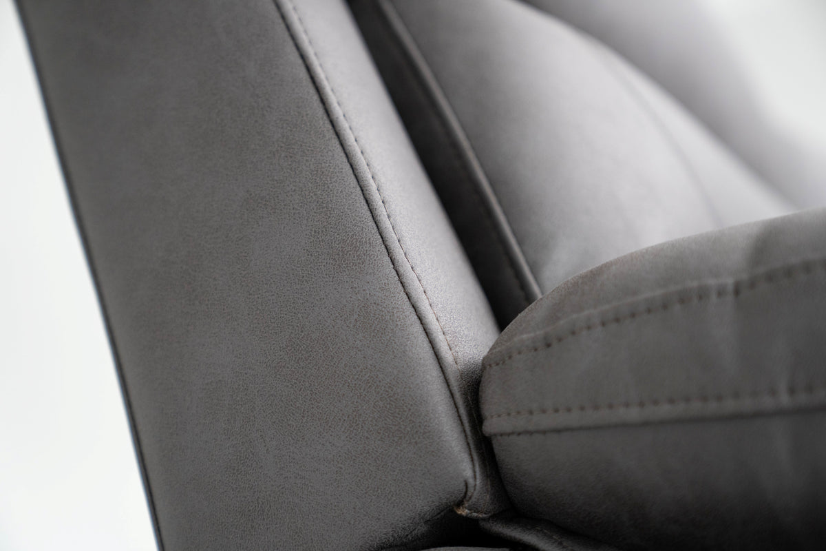 Dark gray sofa arm and cushion edge with contrast stitching details