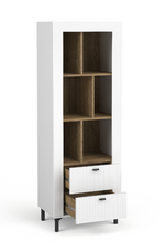 White bookcase with open cubby shelves and two ribbed drawers with gold pulls.