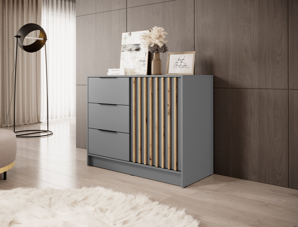 Grey chest of drawers with three drawers and vertical gold-toned slat door panel