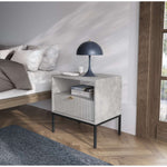 White bedside table in a living room, with ribbed drawer and open shelf.