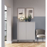 White two-door highboard with vertical ribbed panel doors and black feet