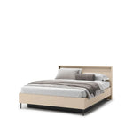 Beige upholstered ottoman bed with headboard, fitted mattress, and gray bedding