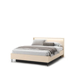 Beige upholstered ottoman bed with headboard and neatly made gray-and-white bedding