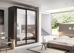 Sliding wardrobe with dark frame and glass doors, shown inside a bedroom.