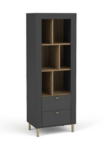 Matte black bookcase with open cubby shelves and two ribbed drawers with gold pulls.