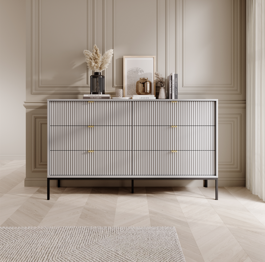Ridge chest of drawers in white with vertical ribbed fronts and brass-tone bar handles.