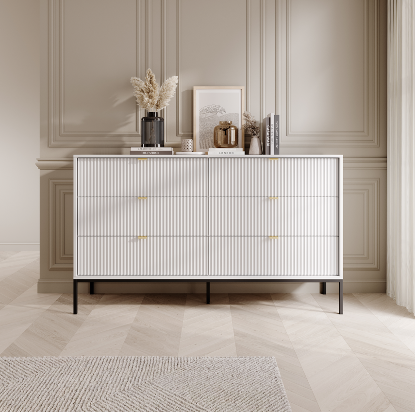 Ridge chest of drawers in white with vertical ribbed fronts and brass-tone bar handles.