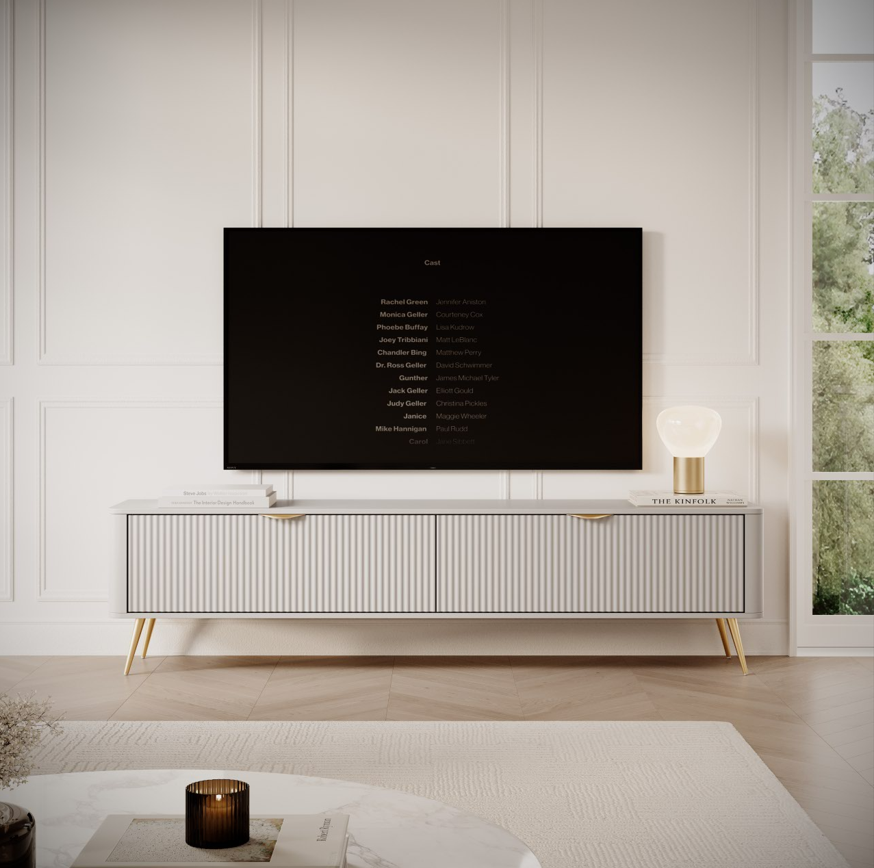 Beige TV console with ribbed cabinet doors and slim gold legs