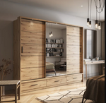 Wood-look sliding wardrobe with mirror and shelves behind open doors in a bedroom.