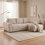 Light fabric corner sofa bed in beige tones with three back cushions and chaise seat