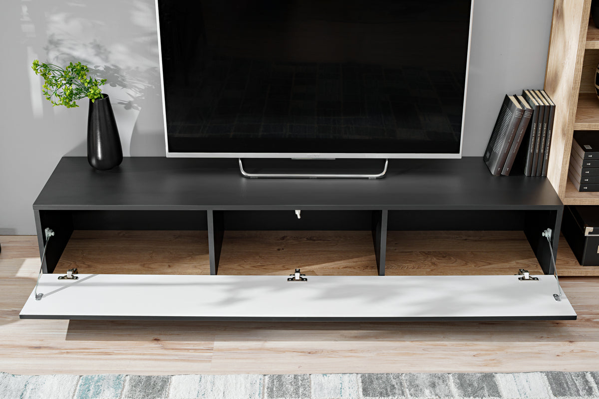 Anthracite media wall unit with swing-down drawer panel open showing cable holes