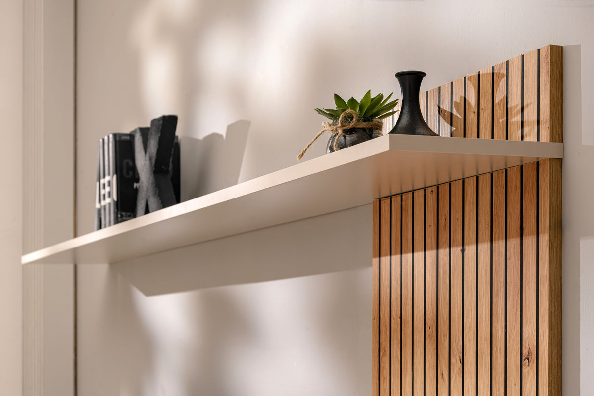 Media wall cabinet with white ledge and vertical slatted door panel in warm wood