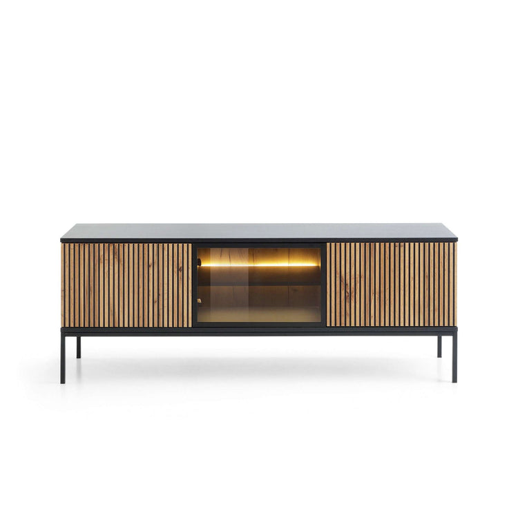 TV cabinet with black top, vertical oak slat doors, glass center opening and warm light
