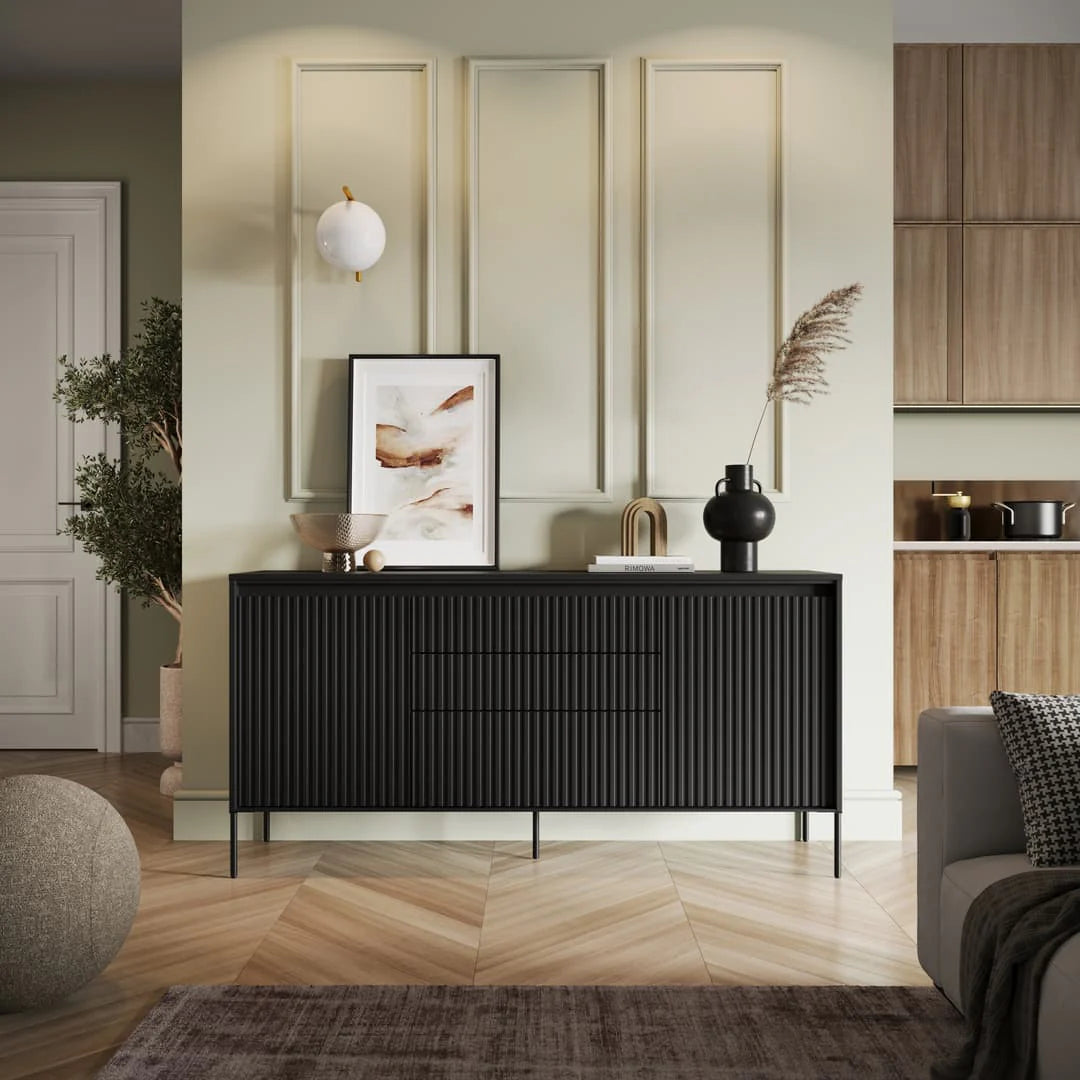 Black sideboard with ribbed doors and three drawer fronts, two-door storage.