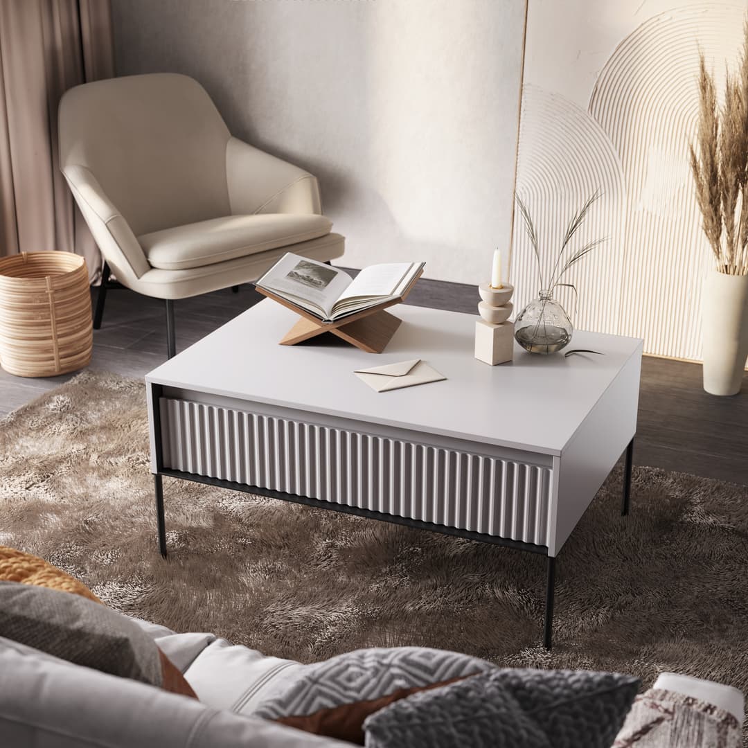 White matt coffee table with ribbed front and flat top surface, on slim metal legs.