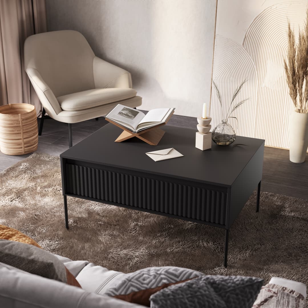 Black coffee table with ribbed front and flat top surface, on slim metal legs.