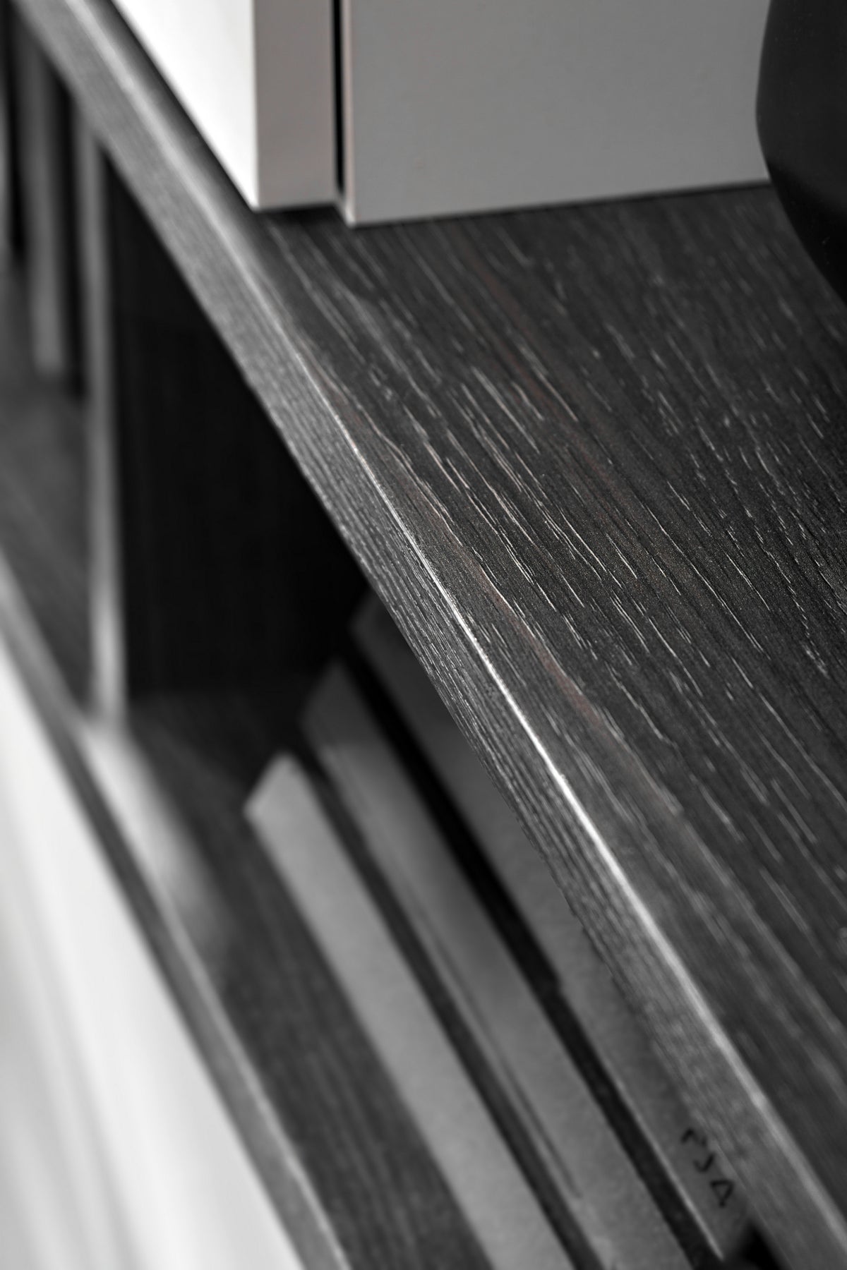 Dark wood media wall unit top shelf with angled edge and textured grain detail