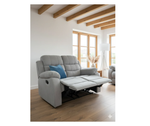 Gray fabric manual recliner with blue side pillow and extended footrest.