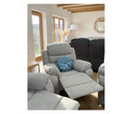 Gray fabric recliner with blue throw pillow, side view, padded arms and seat.
