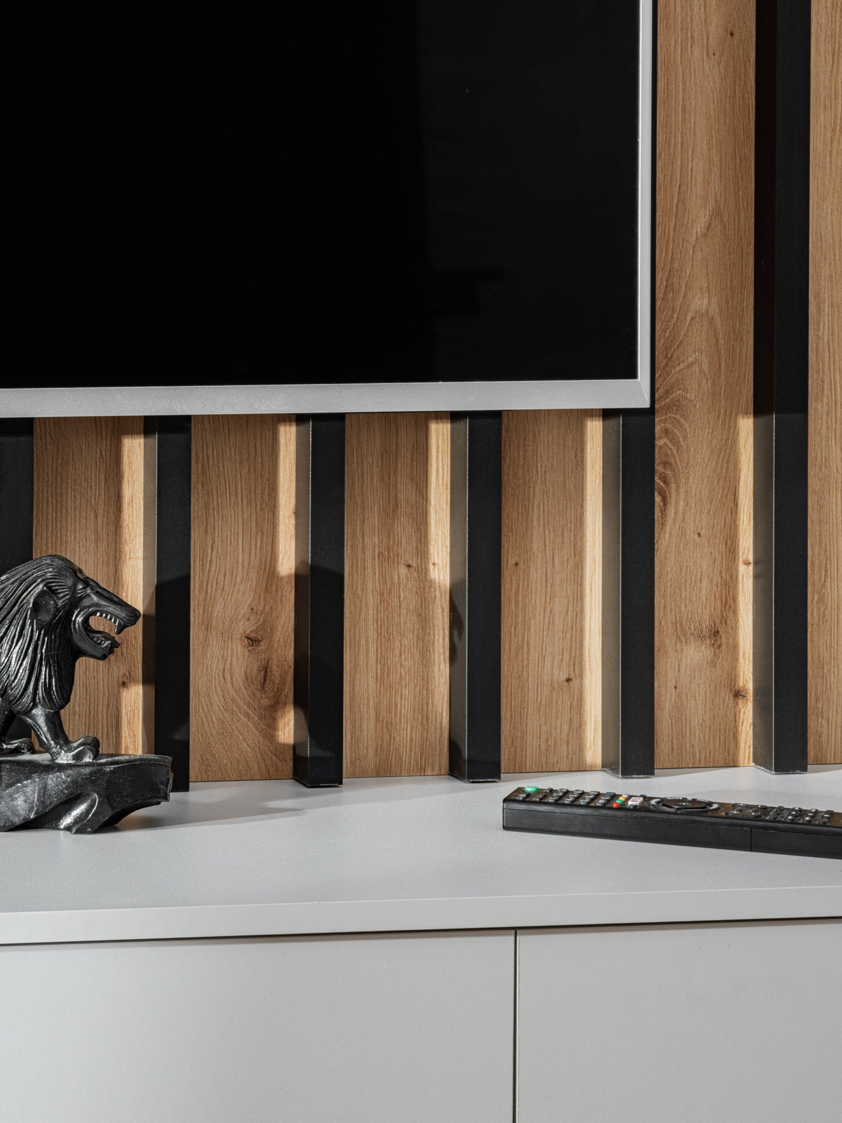 TV wall unit with vertical wood slat back and white low storage cabinet