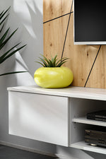 Givi media wall unit with gray cabinet drawer and open media shelf beside yellow plant