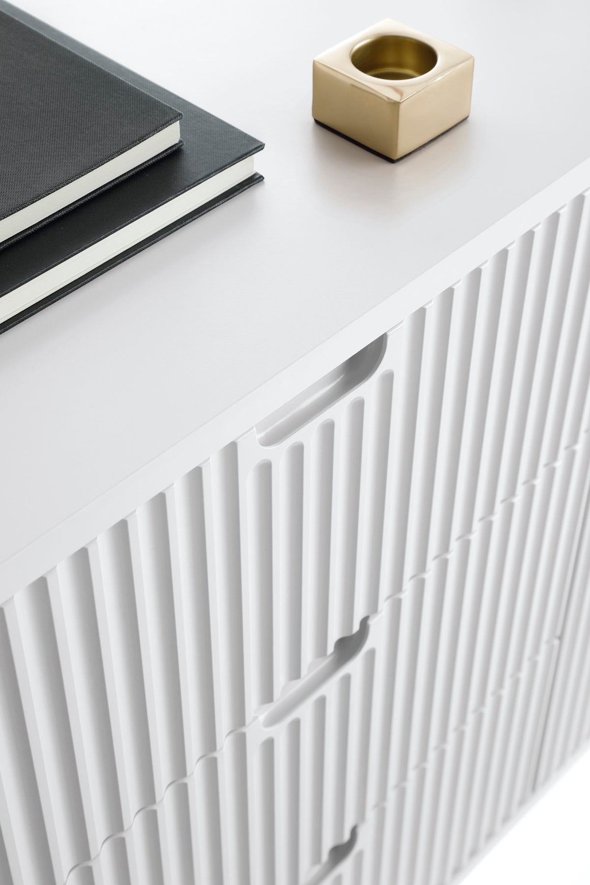 Mila TV cabinet close-up with white fluted door panels and minimal tabletop top.