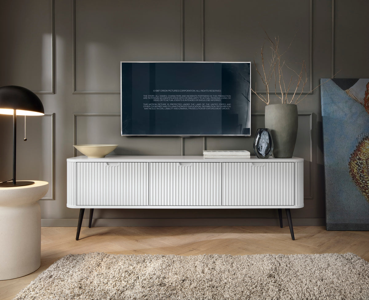 White TV cabinet with fluted front, two drawers, and black legs