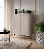 Cashmere highboard cabinet with vertical ribbed doors and tapered legs in a living room